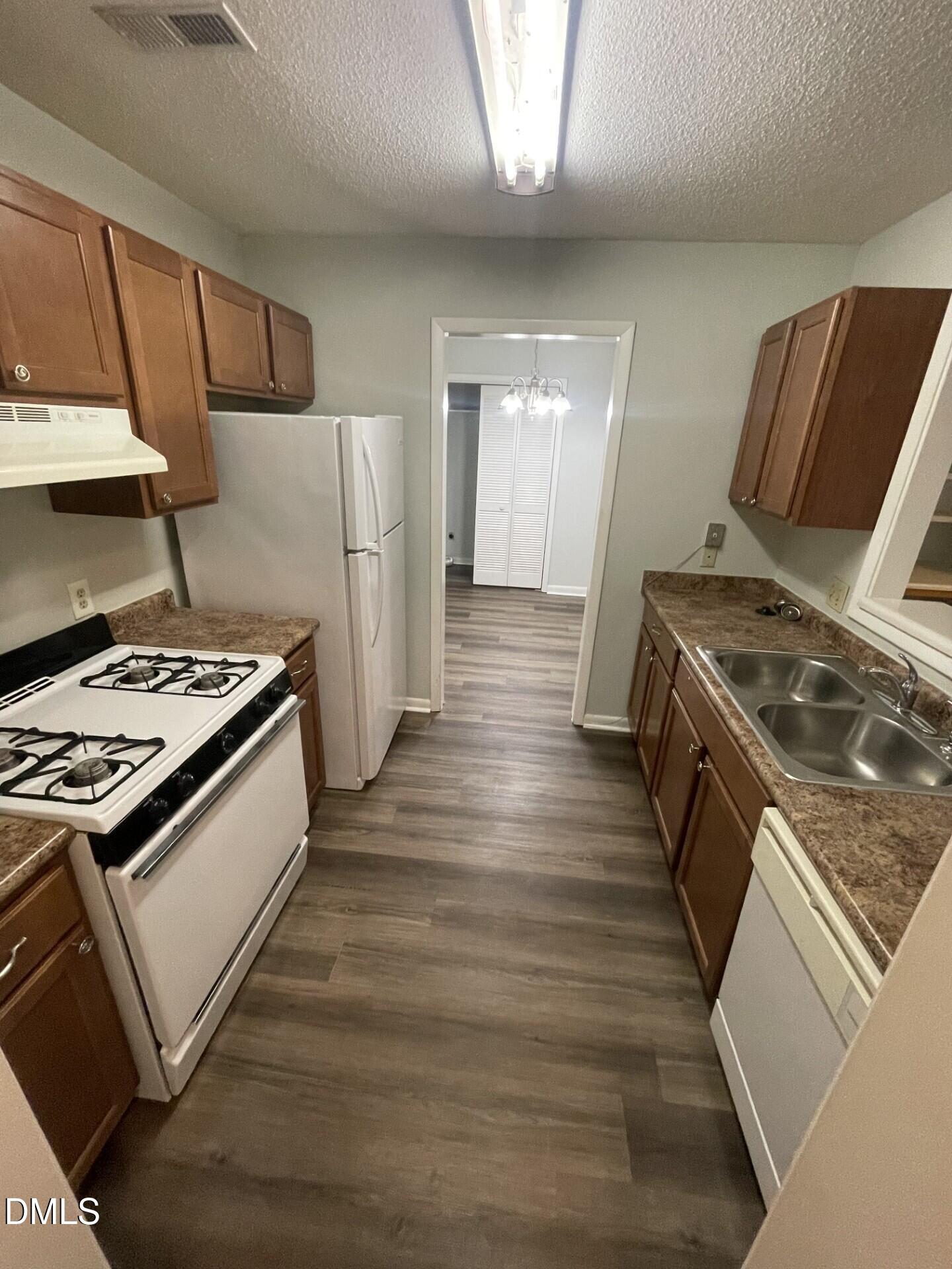 5155 Windy Hill Drive, Unit 202 Raleigh, NC 27609 - Photo 3 of 10 a kitchen with granite countertop a stove and a refrigerator