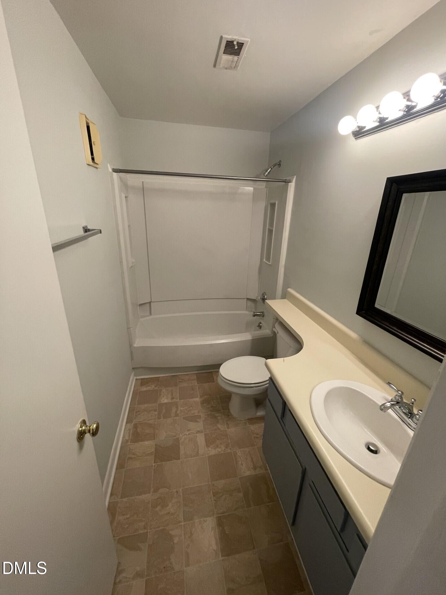 5155 Windy Hill Drive, Unit 202 Raleigh, NC 27609 - Photo 6 of 10 a bathroom with a sink a toilet a mirror and shower