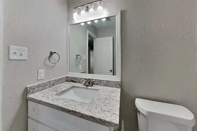 a bathroom with a granite countertop sink and a mirror