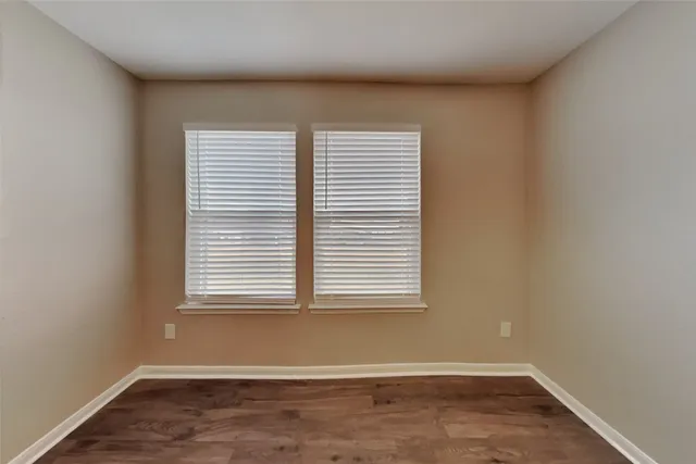 an empty room with wooden floor and a window