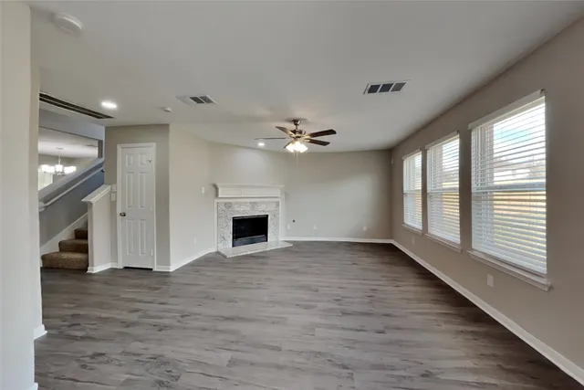 a view of an empty room with a fireplace and a window