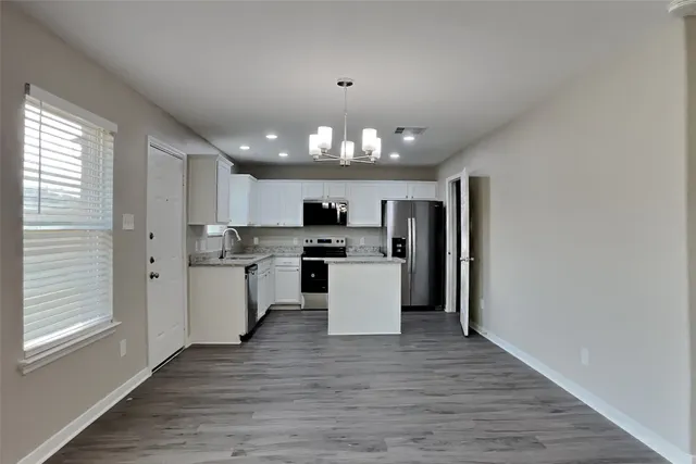 a kitchen with a white cabinets and kitchen island