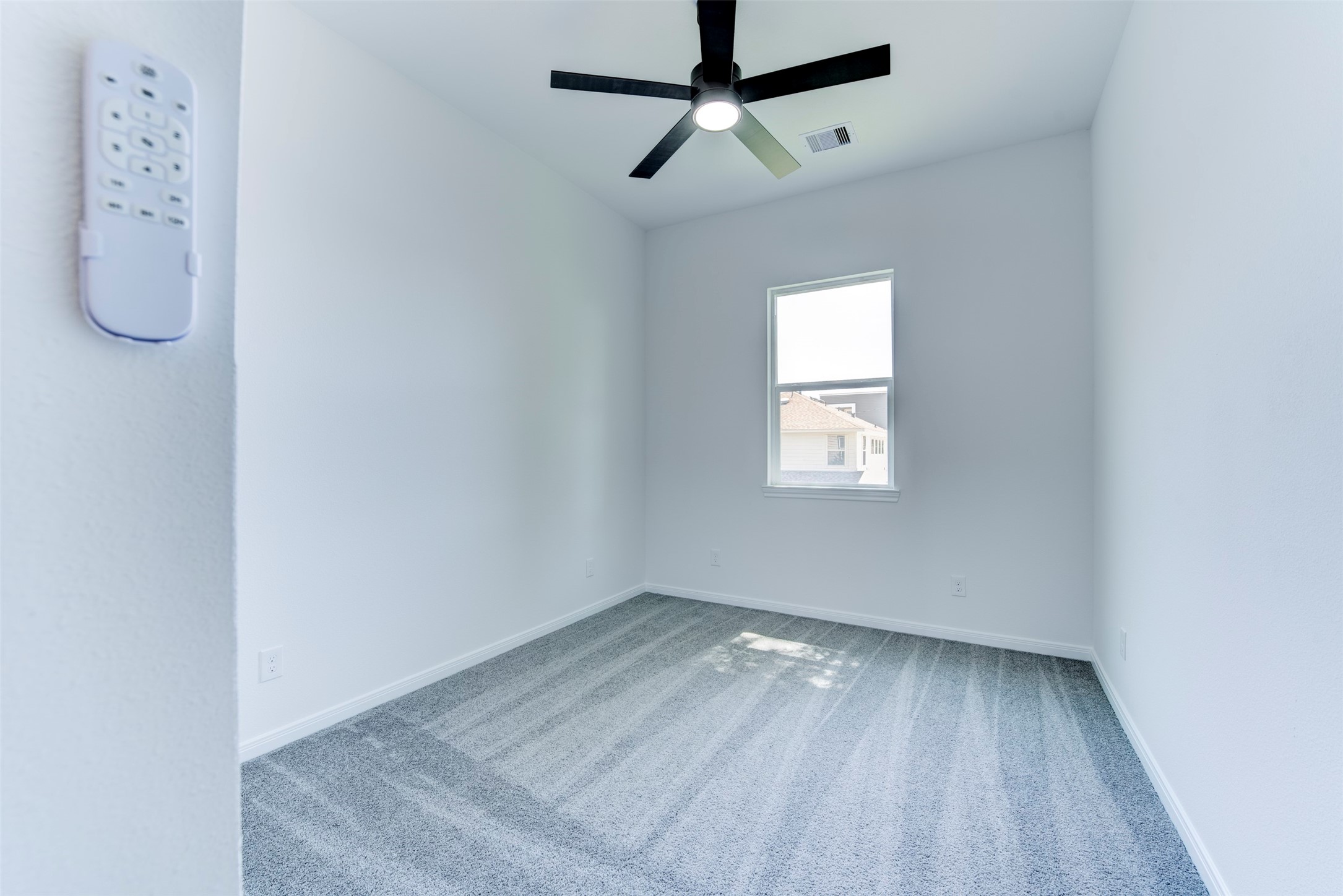 6807 Paris Street Houston, TX 77021 - Photo 23 of 37 Additional secondary bedroom with plush carpet, a ceiling fan with integrated light kit, and a large window bringing in natural light. Clean, neutral finishes create a bright and comfortable space.