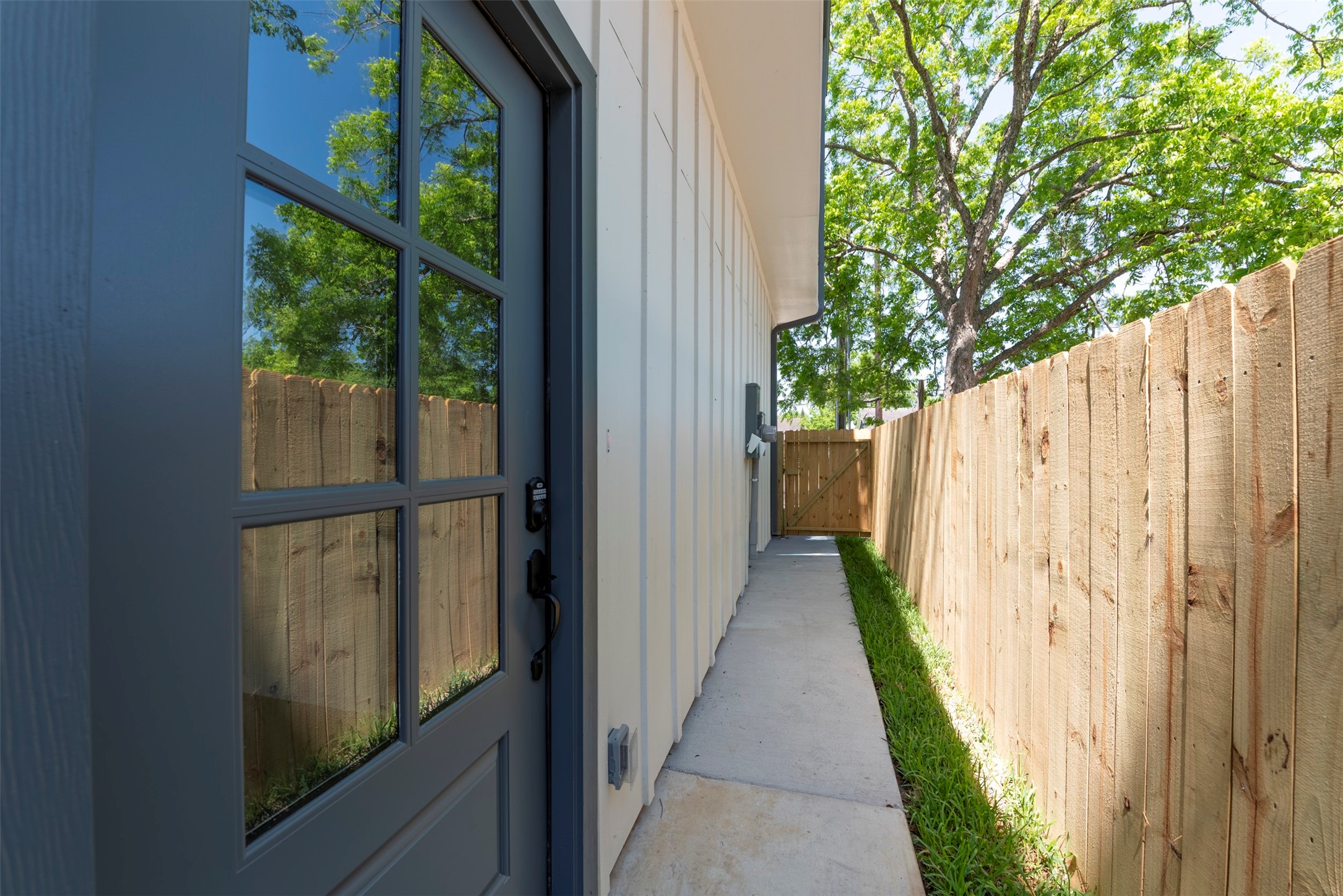 6807 Paris Street Houston, TX 77021 - Photo 32 of 37 Private side yard with a clean concrete pathway leading directly to the front door, offering convenient access and a functional outdoor corridor.