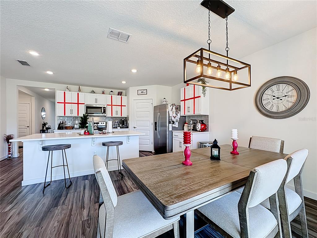 348 Talisi Loop St. Cloud, FL 34771 - Photo 11 of 35 a kitchen with a table chairs and white cabinets