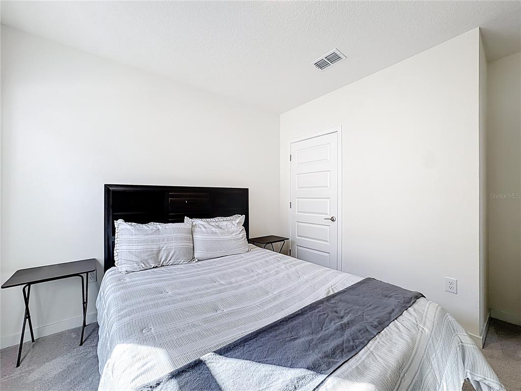 348 Talisi Loop St. Cloud, FL 34771 - Photo 18 of 35 a bedroom with a bed and a night stand