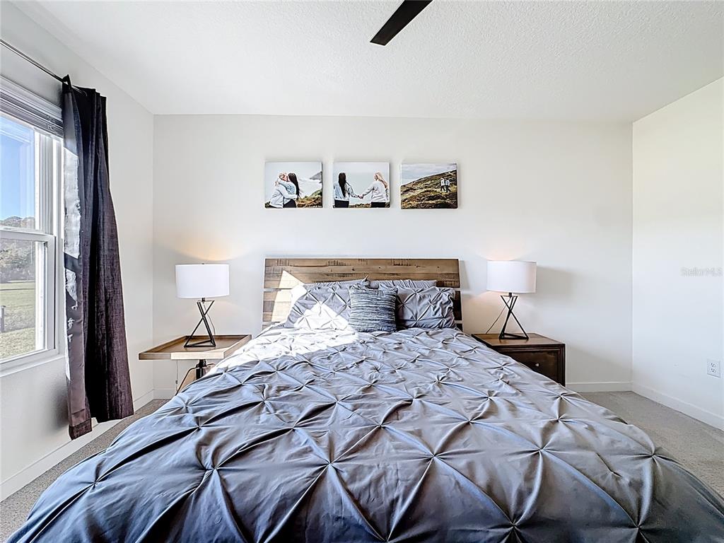 348 Talisi Loop St. Cloud, FL 34771 - Photo 24 of 35 a bedroom with a bed and lamp with window