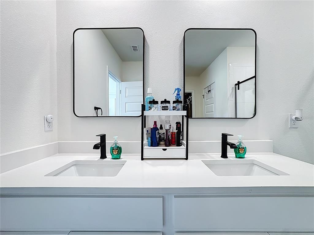 348 Talisi Loop St. Cloud, FL 34771 - Photo 27 of 35 a bathroom with double vanity sinks and a mirror