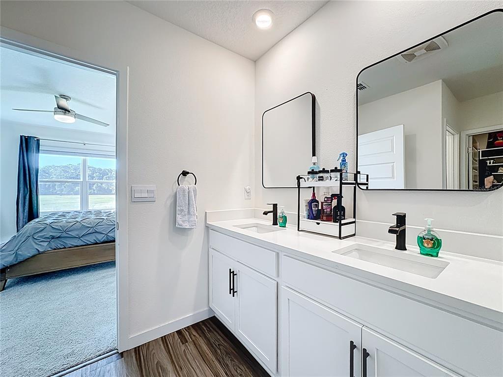 348 Talisi Loop St. Cloud, FL 34771 - Photo 29 of 35 a en suite bathroom with a double vanity sink and mirror
