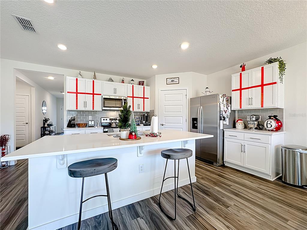348 Talisi Loop St. Cloud, FL 34771 - Photo 7 of 35 a kitchen with sink a refrigerator and chairs