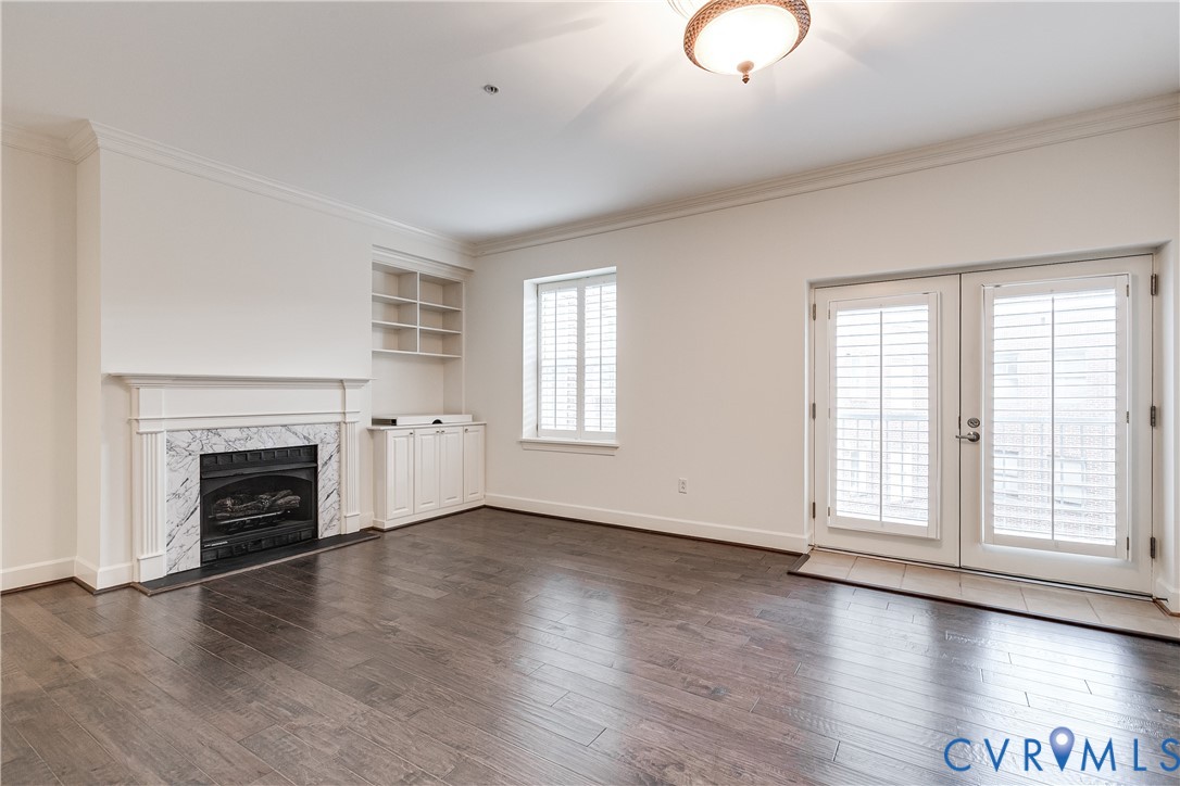413 Stuart Circle, Unit 3D Richmond, VA 23220 - Photo 11 of 26 an empty room with wooden floor fireplace and windows