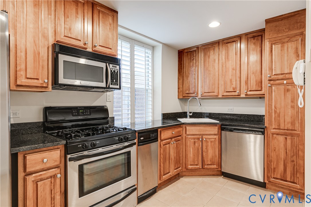 413 Stuart Circle, Unit 3D Richmond, VA 23220 - Photo 14 of 26 a kitchen with granite countertop cabinets stainless steel appliances and wooden cabinets