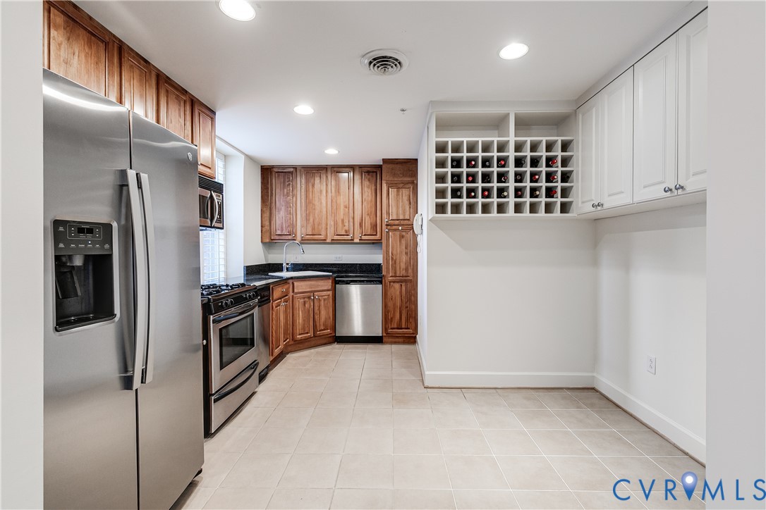 413 Stuart Circle, Unit 3D Richmond, VA 23220 - Photo 15 of 26 a kitchen with granite countertop a refrigerator and a stove top oven