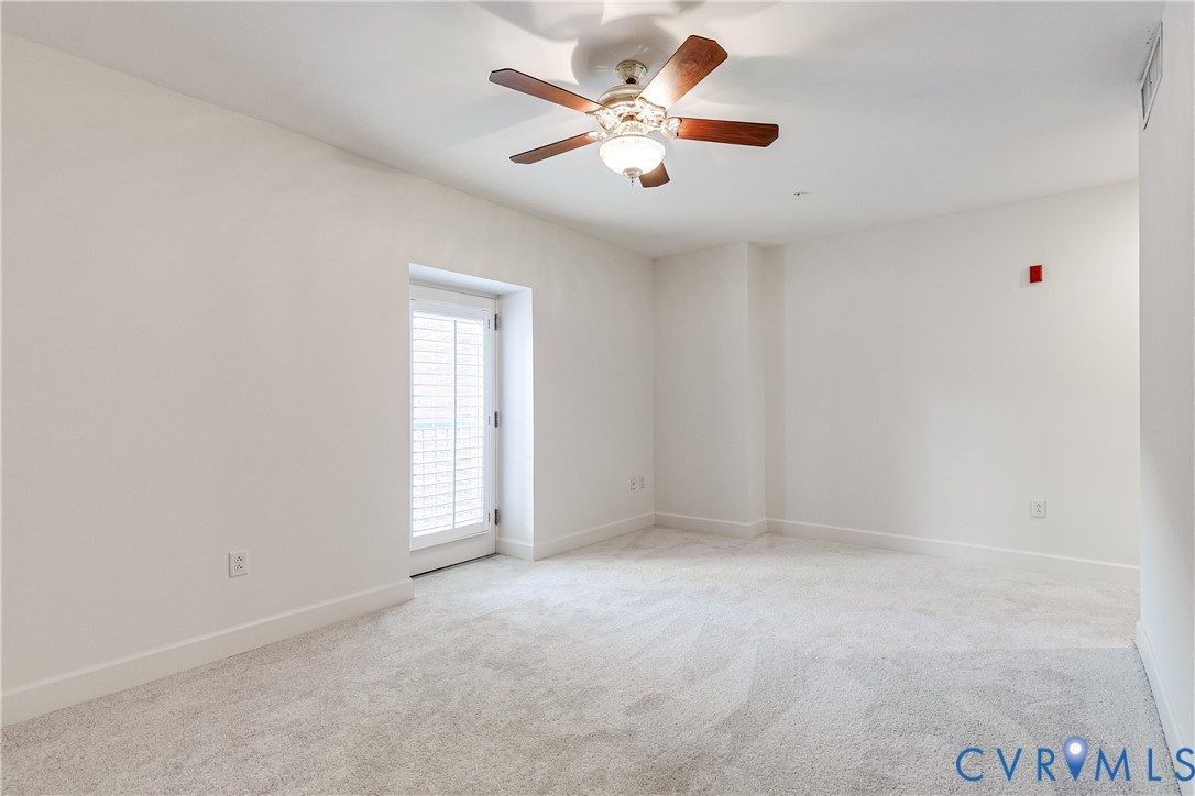 413 Stuart Circle, Unit 3D Richmond, VA 23220 - Photo 22 of 26 an empty room with a window and a ceiling fan