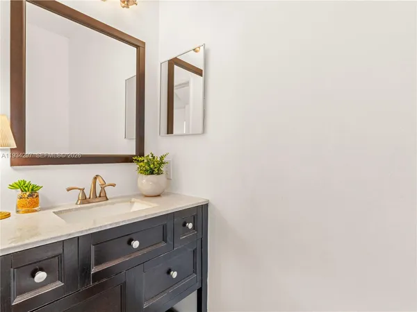 a bathroom with a granite countertop sink and a mirror