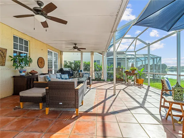 a living room with patio furniture and a floor to ceiling window