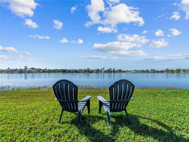 a view of a lake with table and chairs