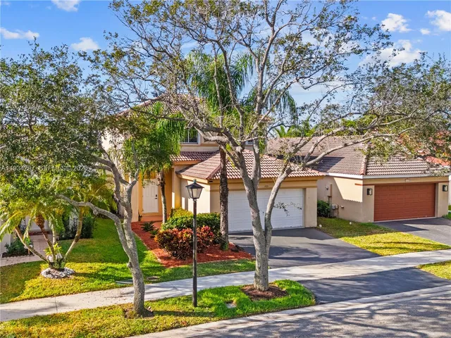 a view of a house with backyard and tree