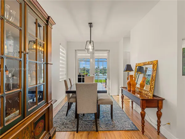 a dining room with furniture a chandelier and wooden floor