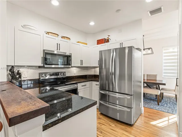 a kitchen with granite countertop a refrigerator stove and microwave