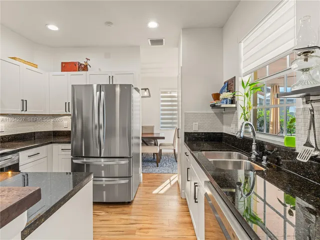 a kitchen with granite countertop a sink appliances and cabinets