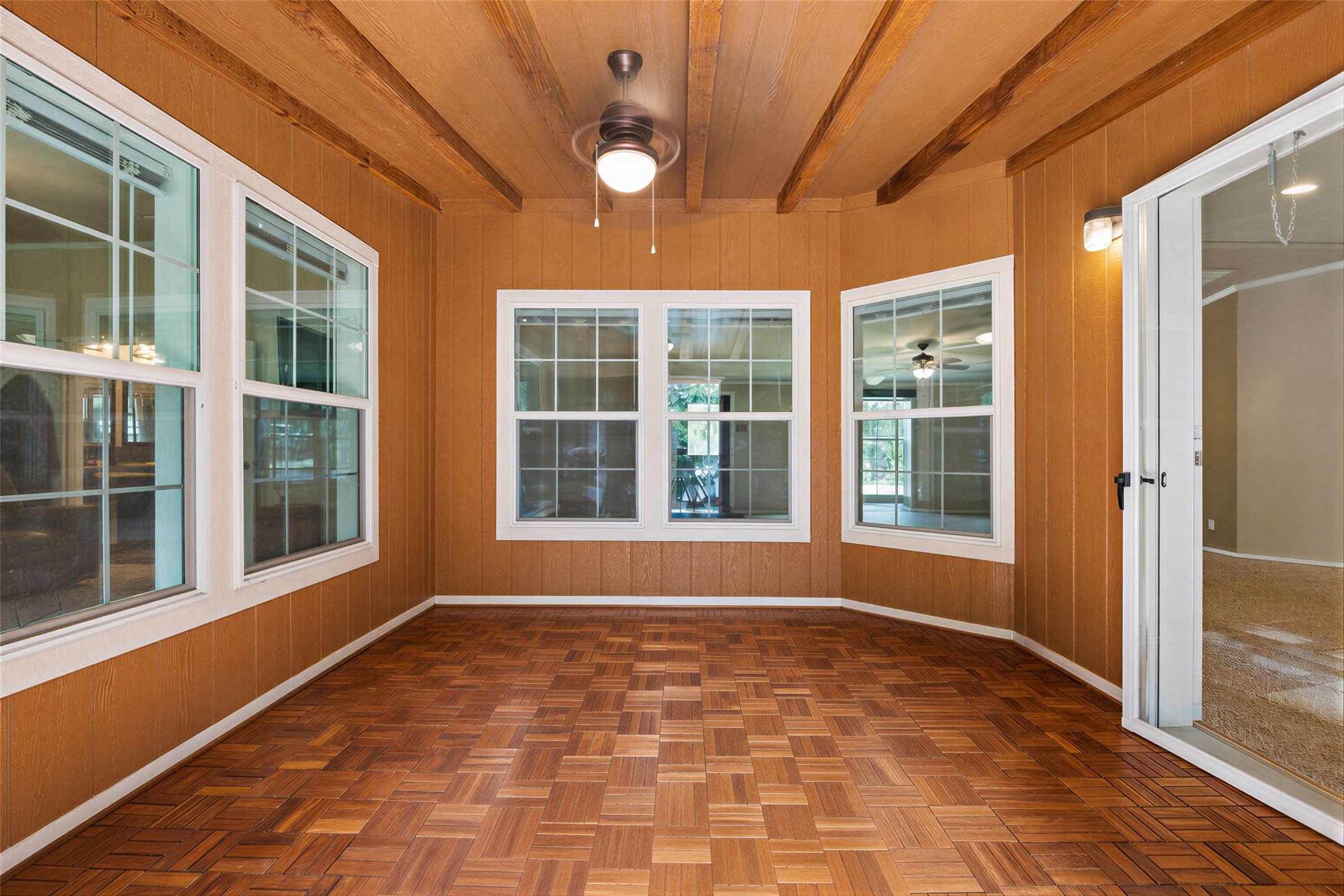 1024 Sand Hills Road Red Rock, TX 78662 - Photo 23 of 40 Sunroom boasting rich wood paneling, exposed beam ceilings, and a geometric wood floor.