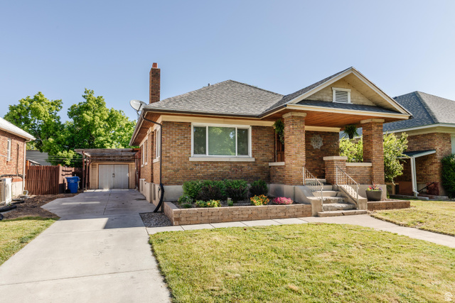 227 West 200 North Logan, UT 84321 - Photo 2 of 44 Brick exterior featuring a covered front porch with decorative columns, concrete steps with metal railings, and a landscaped planter box