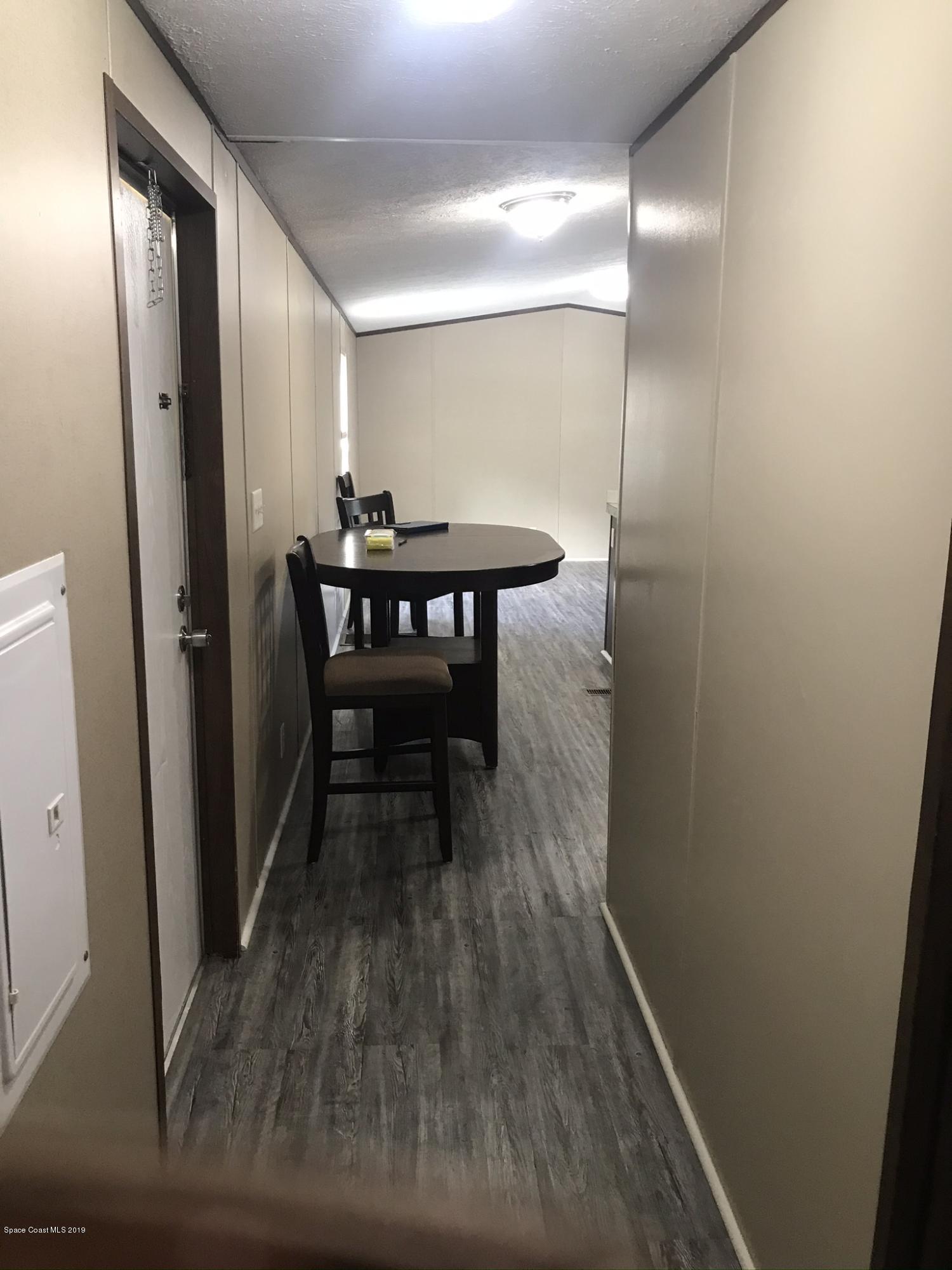 535 Baker Road Merritt Island, FL 32953 - Photo 13 of 34 a view of a hallway with wooden floor and furniture
