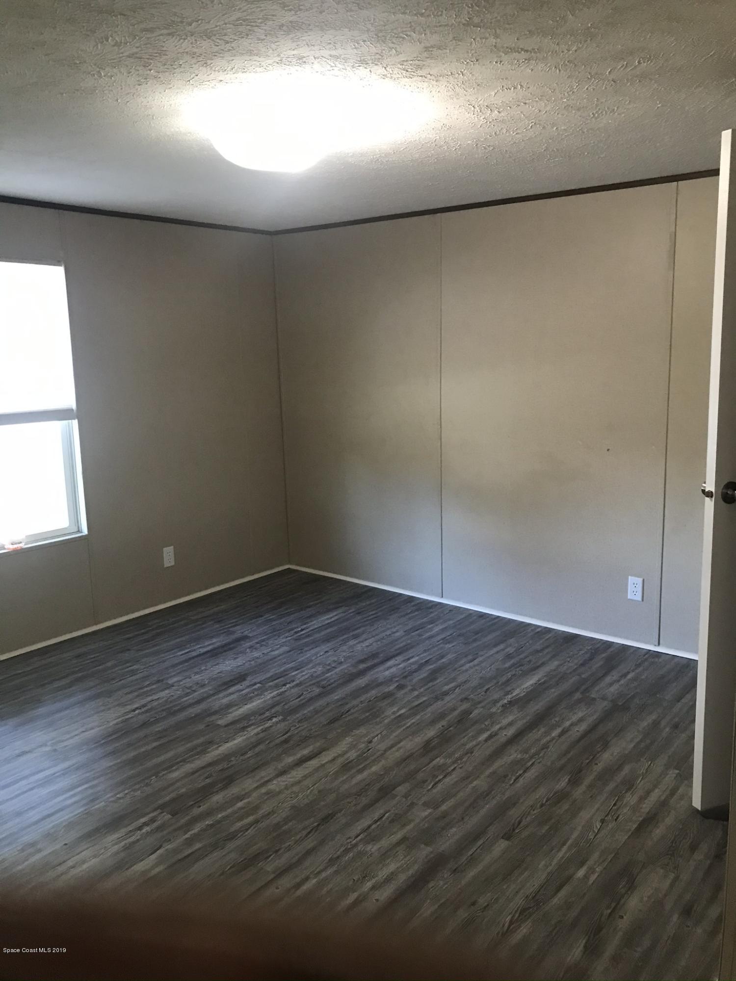 535 Baker Road Merritt Island, FL 32953 - Photo 14 of 34 an empty room with wooden floor and windows