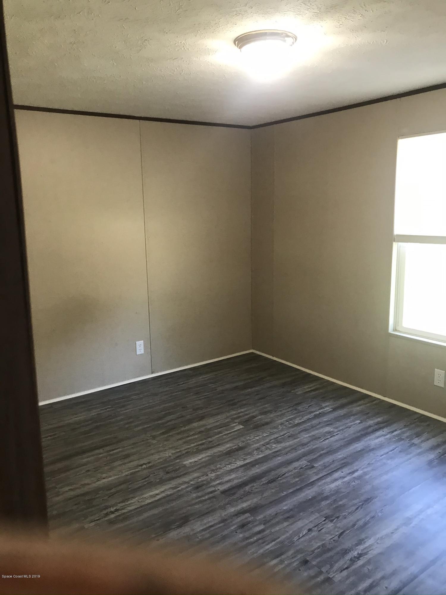 535 Baker Road Merritt Island, FL 32953 - Photo 20 of 34 an empty room with wooden floor and windows