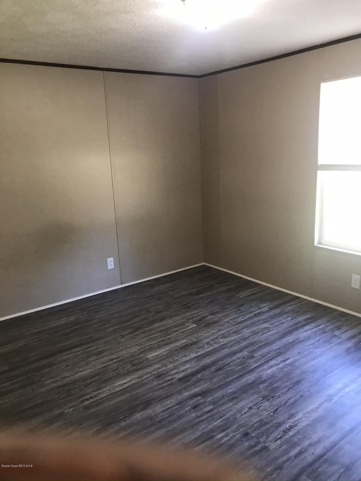 535 Baker Road Merritt Island, FL 32953 - Photo 21 of 34 a view of an empty room with wooden floor and a window