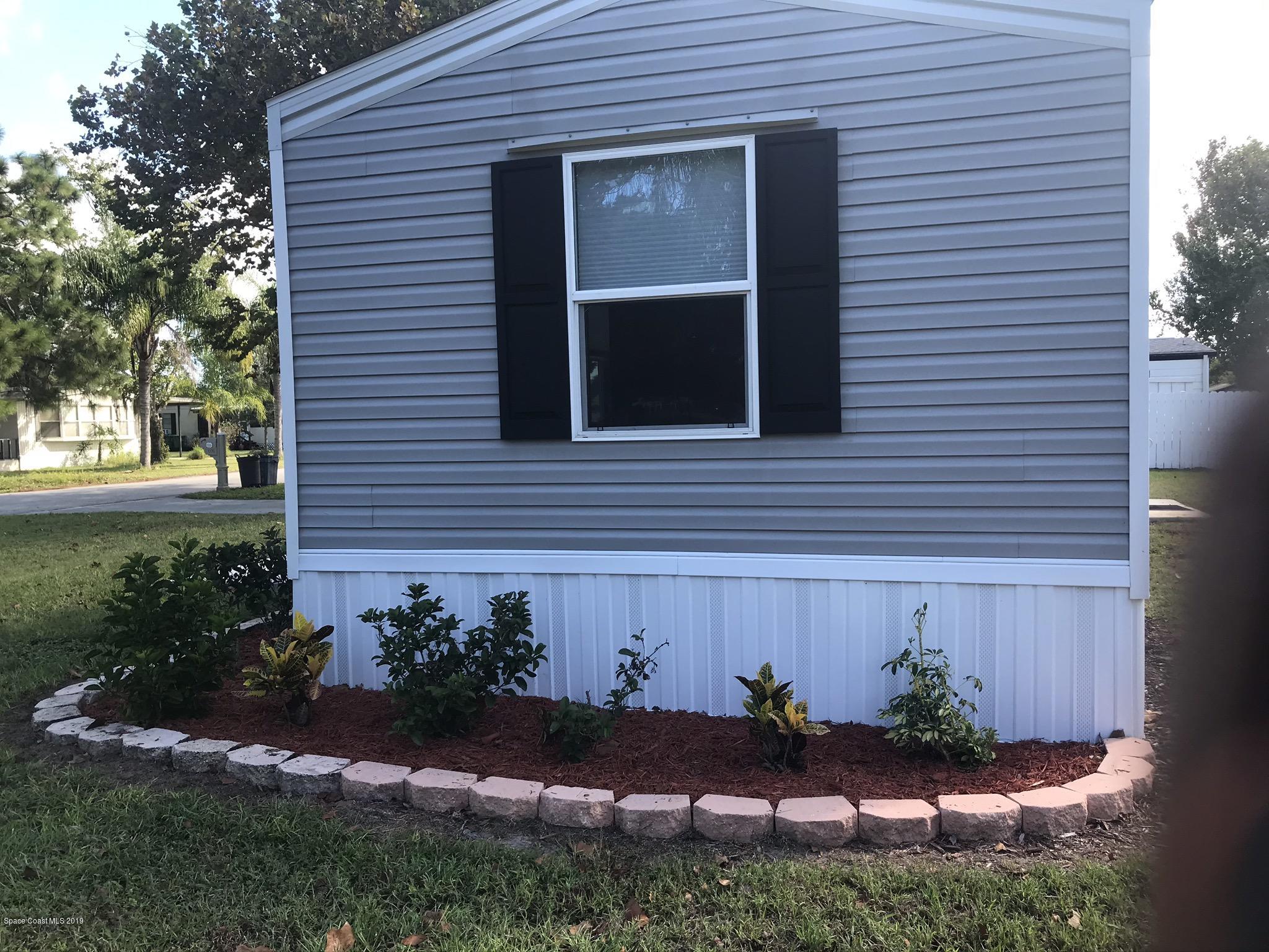 535 Baker Road Merritt Island, FL 32953 - Photo 31 of 34 a view of a house with potted plants and a bench