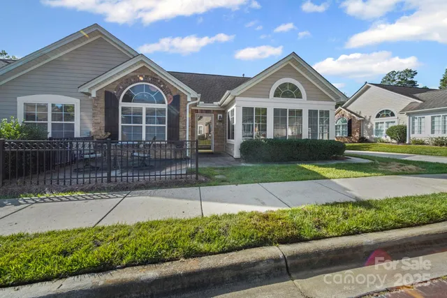 a front view of a house with a yard and potted plants