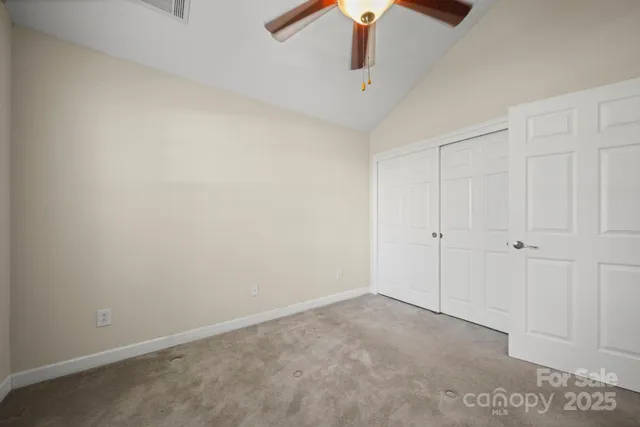an empty room with a ceiling fan and a window