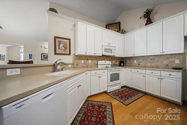 a kitchen with granite countertop a sink stainless steel appliances and cabinets