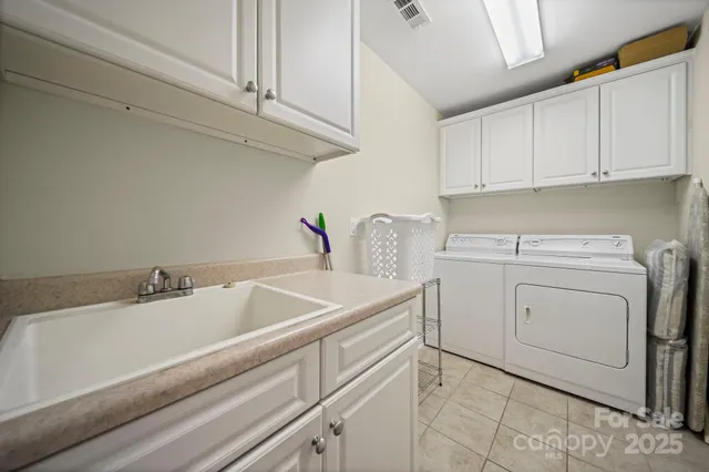 a utility room with sink dryer and washer