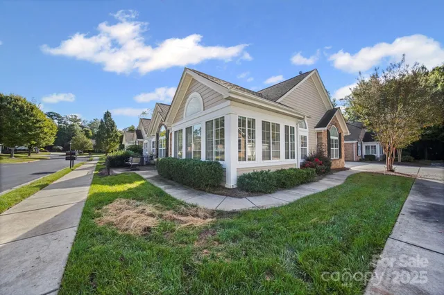 a view of a house with a big yard plants and large trees