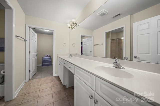 a spacious bathroom with a double vanity sink a mirror and a bathtub