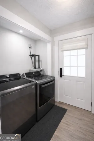 a bedroom with a large bed a flat tv screen and dresser
