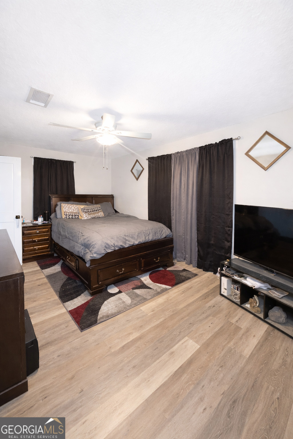 543 Church Street Blackshear, GA 31516 - Photo 20 of 35 a spacious bedroom with a bed and a flat screen tv