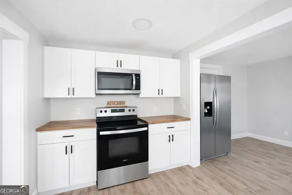 a kitchen with granite countertop a sink cabinets and stainless steel appliances
