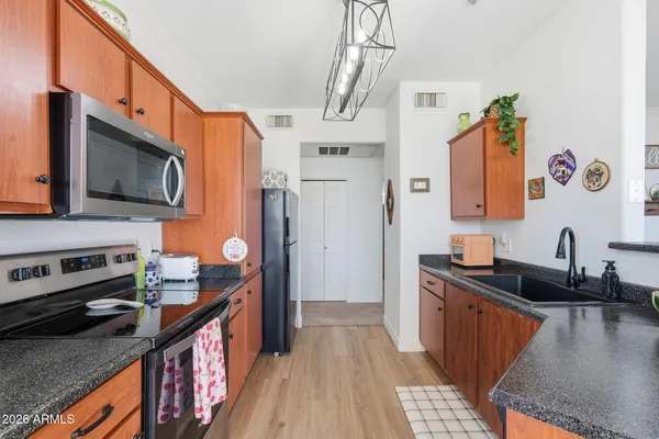 a kitchen with stainless steel appliances kitchen island granite countertop a refrigerator a stove top oven a sink and dishwasher