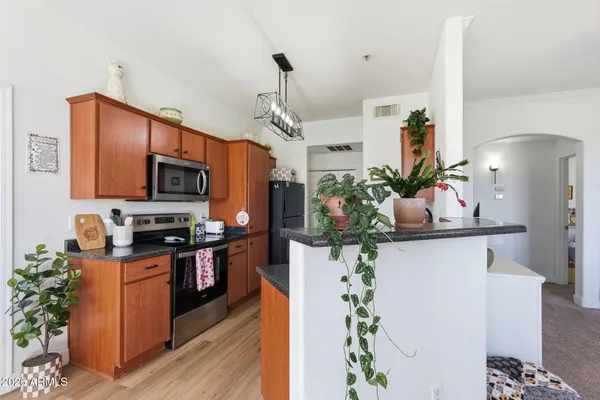 a kitchen with granite countertop a sink a counter space appliances and cabinets