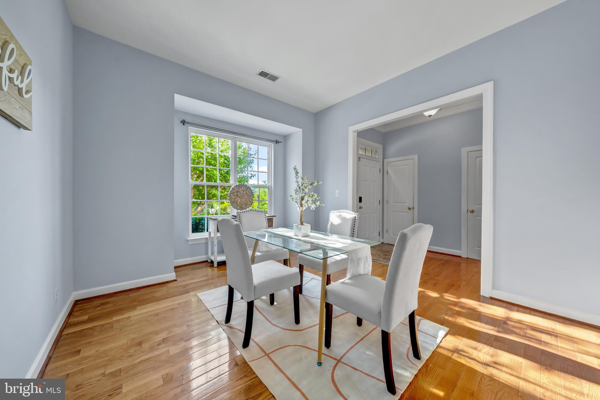 9231 Ribbon Falls Loop Bristow, VA 20136 - Photo 17 of 40 a view of a dining room with furniture a rug and wooden floor