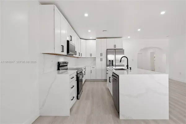 a kitchen with white cabinets and stainless steel appliances