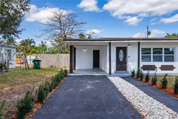 a view of a house with a yard and potted plants