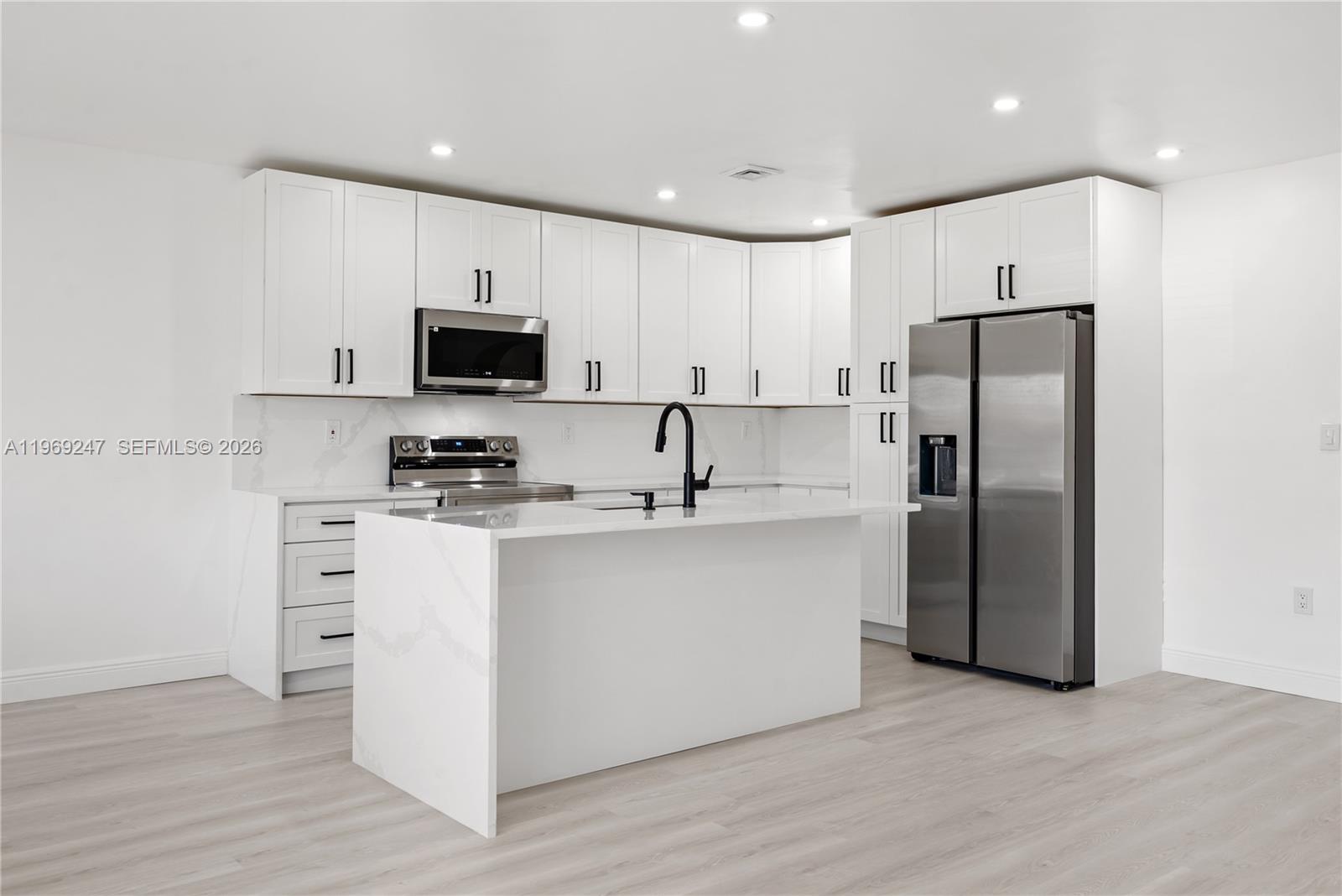 3341 Northwest 7th Street Lauderhill, FL 33311 - Photo 2 of 21 a kitchen with stainless steel appliances a refrigerator stove and microwave