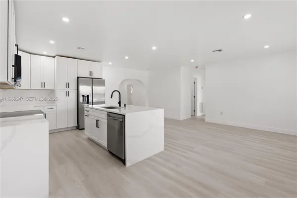 a kitchen with a sink stainless steel appliances and white cabinets