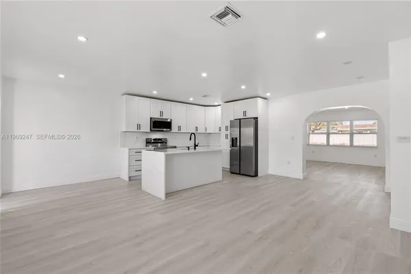 a view of a kitchen with refrigerator and windows