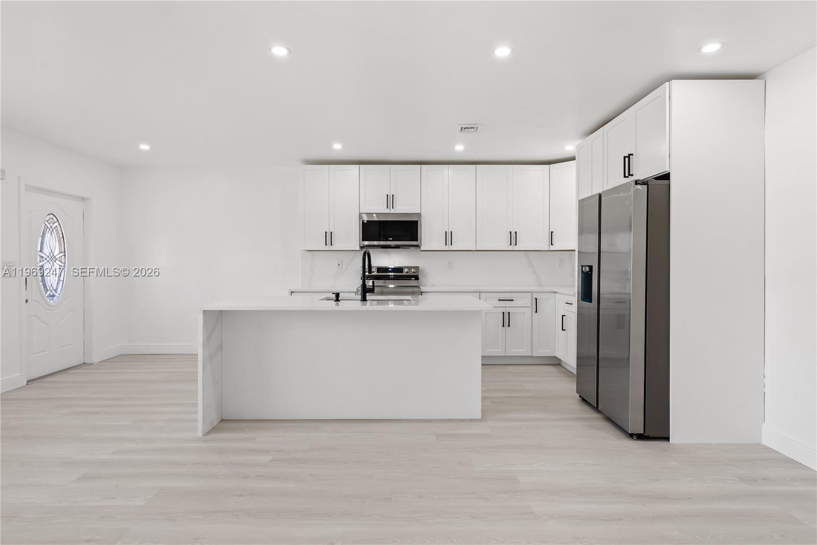 3341 Northwest 7th Street Lauderhill, FL 33311 - Photo 5 of 21 a kitchen with white cabinets and stainless steel appliances